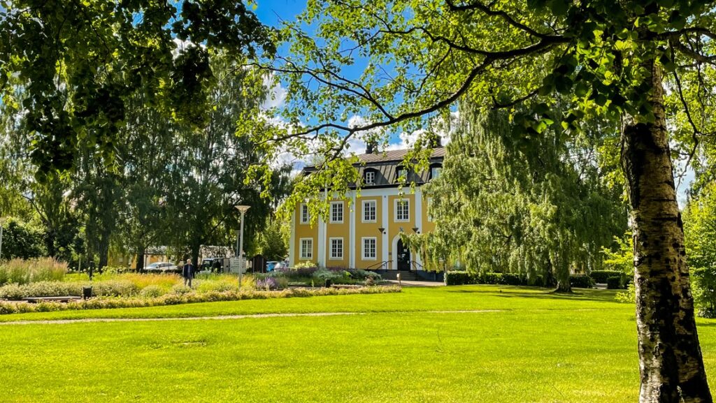 Stadshusparken med Avesta kommuns gula stadshus i bakgrunden.