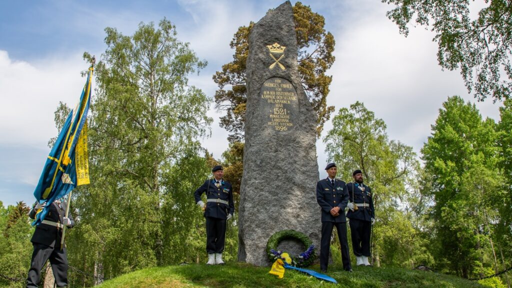 Några människor står kring Gustav Vasas minnessten i Brunnbäck.