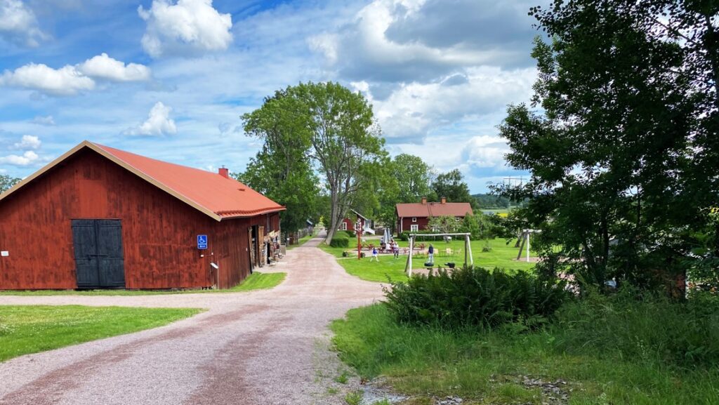 Bondgård med röda boningshus och stor rödmålad ladugård.